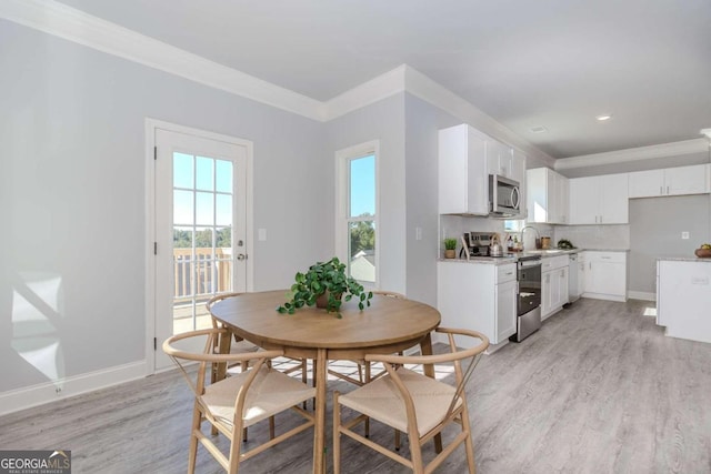 dining room featuring light hardwood / wood-style flooring and ornamental molding