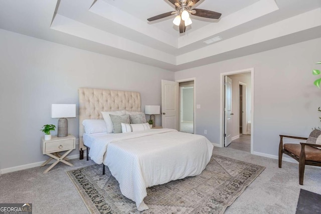 bedroom with a tray ceiling, carpet, and ceiling fan