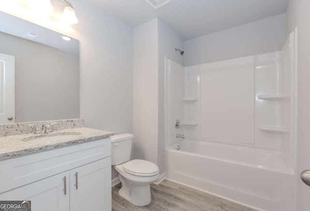 full bathroom with vanity, hardwood / wood-style floors, shower / bathing tub combination, and toilet