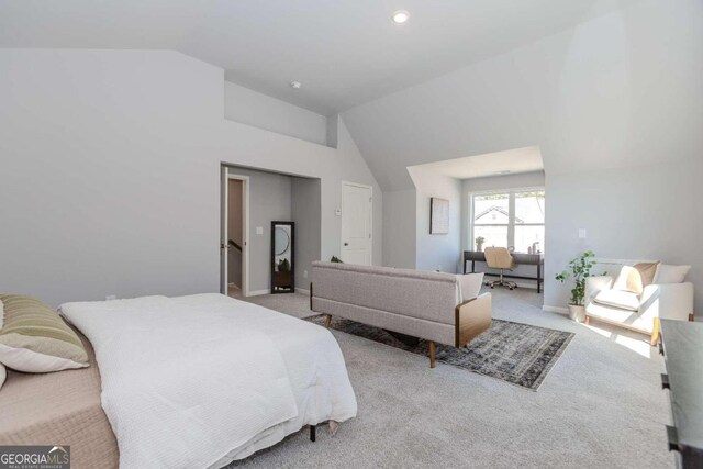 bedroom with light carpet and high vaulted ceiling