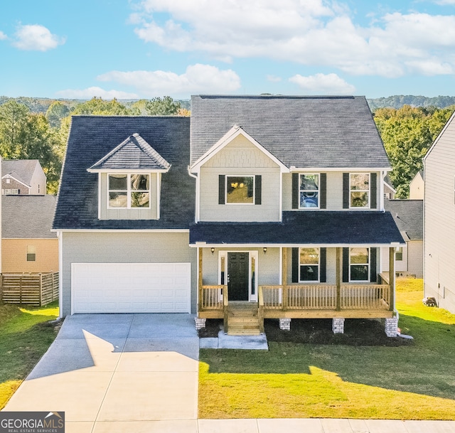 view of front of property with a porch, a front lawn, and a garage