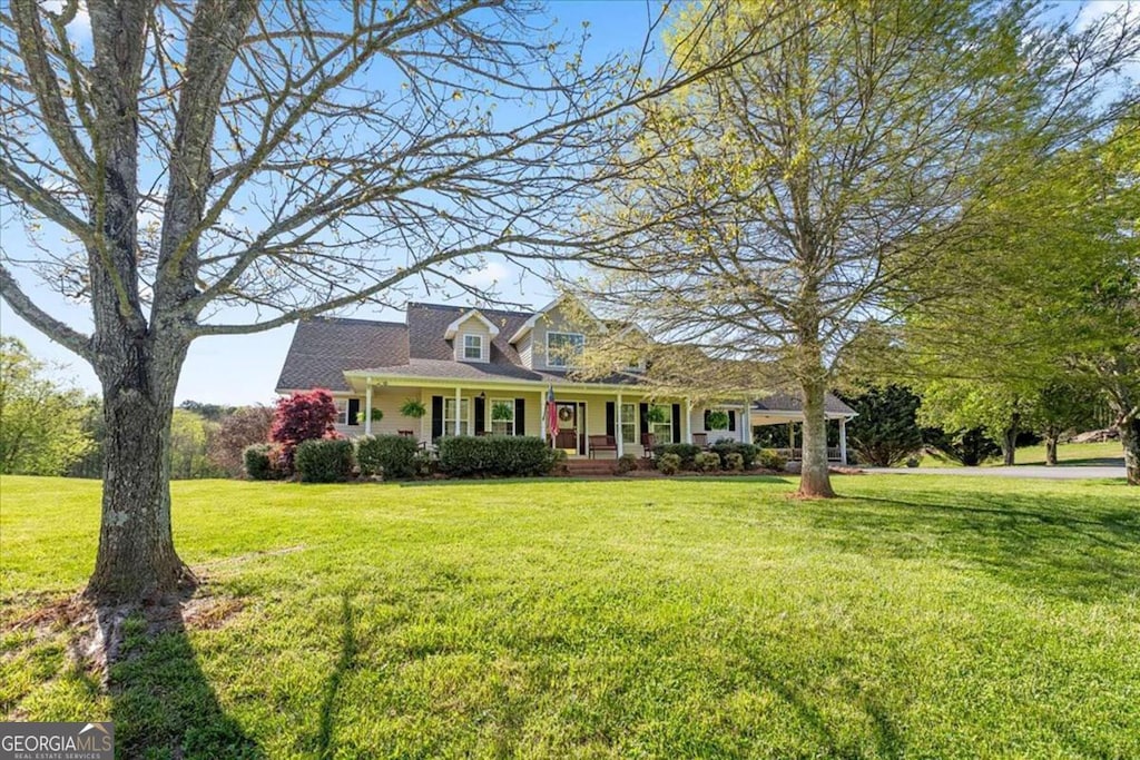 cape cod-style house with a front yard and covered porch