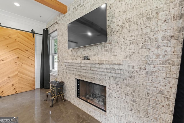 unfurnished living room featuring a brick fireplace and beam ceiling