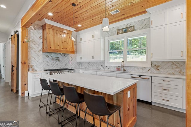 kitchen with pendant lighting, dishwasher, white cabinetry, backsplash, and a center island