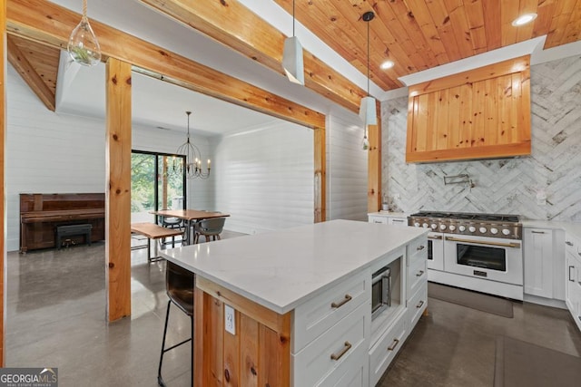 kitchen featuring pendant lighting, tasteful backsplash, white cabinets, range with two ovens, and a center island