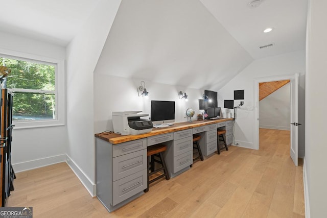 home office featuring vaulted ceiling and light hardwood / wood-style flooring