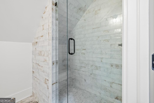 bathroom featuring vaulted ceiling and a shower with shower door