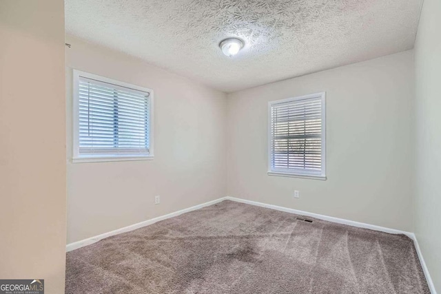 spare room with carpet floors and a textured ceiling