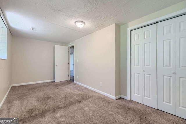 unfurnished bedroom featuring a closet, a textured ceiling, and carpet floors