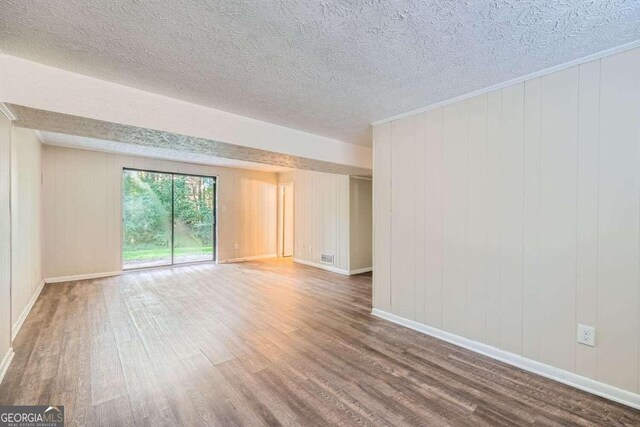 4660 Edwina Ln SW, Atlanta, GA 30331 - empty room with wood finished floors, a textured ceiling, and baseboards