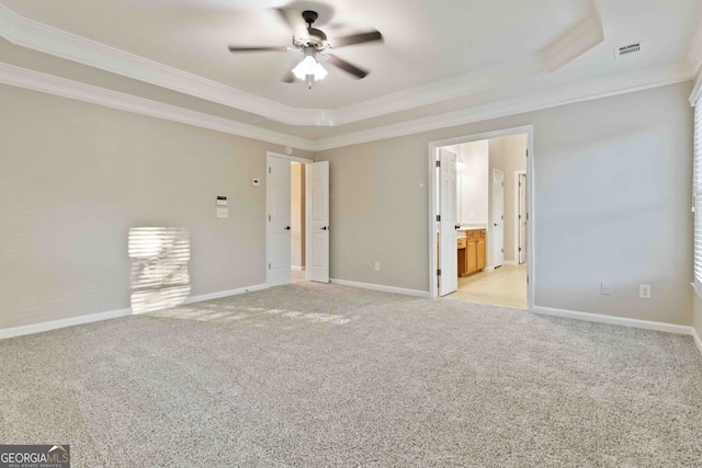 carpeted empty room featuring crown molding, a tray ceiling, and ceiling fan