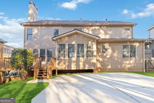 back of house featuring a deck and a yard