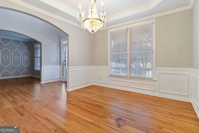 unfurnished dining area featuring crown molding, hardwood / wood-style flooring, and a tray ceiling