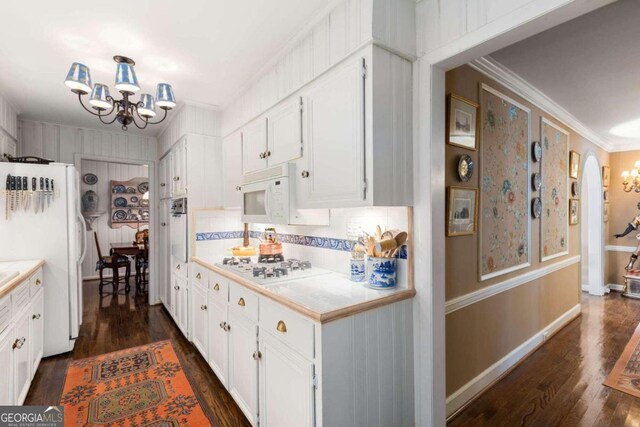 kitchen with dark hardwood / wood-style flooring, crown molding, white cabinetry, and white appliances