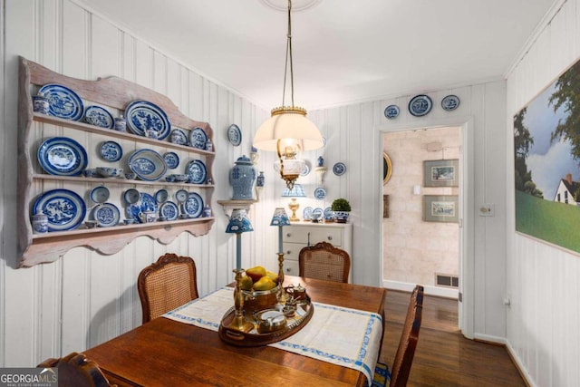 dining space featuring ornamental molding and dark hardwood / wood-style flooring