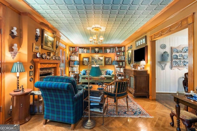 sitting room with an inviting chandelier, ornamental molding, and light parquet flooring