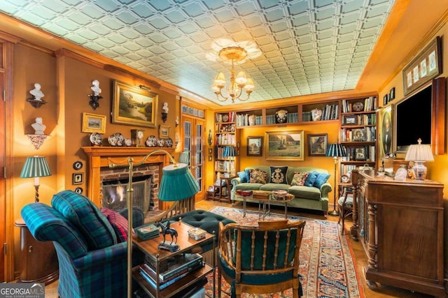 sitting room featuring crown molding, a fireplace, and an inviting chandelier