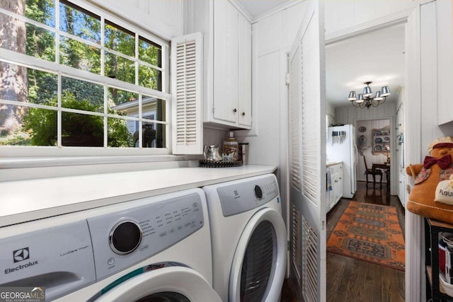 laundry room featuring cabinets, washer and dryer, a chandelier, and dark hardwood / wood-style floors