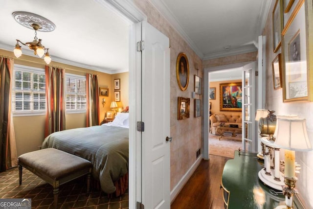 bedroom featuring crown molding, dark hardwood / wood-style floors, and a chandelier