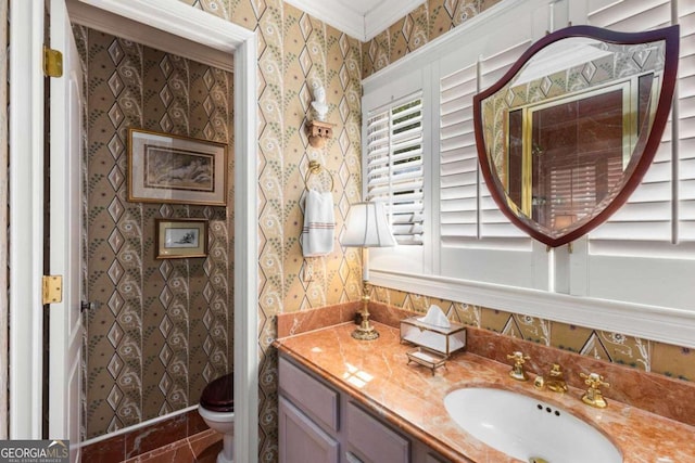 bathroom with vanity, toilet, and ornamental molding