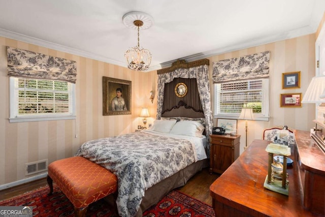 bedroom with crown molding, an inviting chandelier, and dark hardwood / wood-style flooring