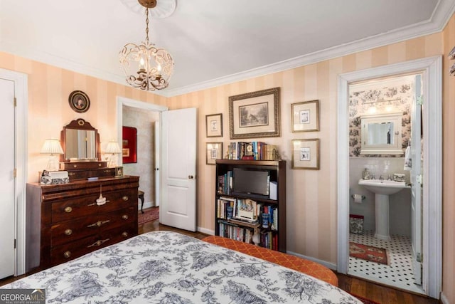 bedroom featuring crown molding, hardwood / wood-style floors, ensuite bath, and a notable chandelier