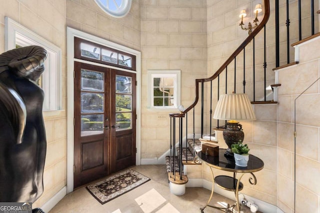 entrance foyer featuring french doors and tile walls