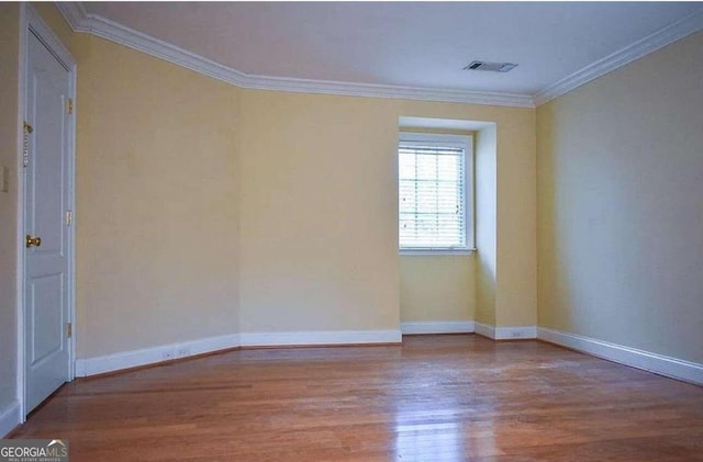 unfurnished room featuring crown molding and hardwood / wood-style flooring