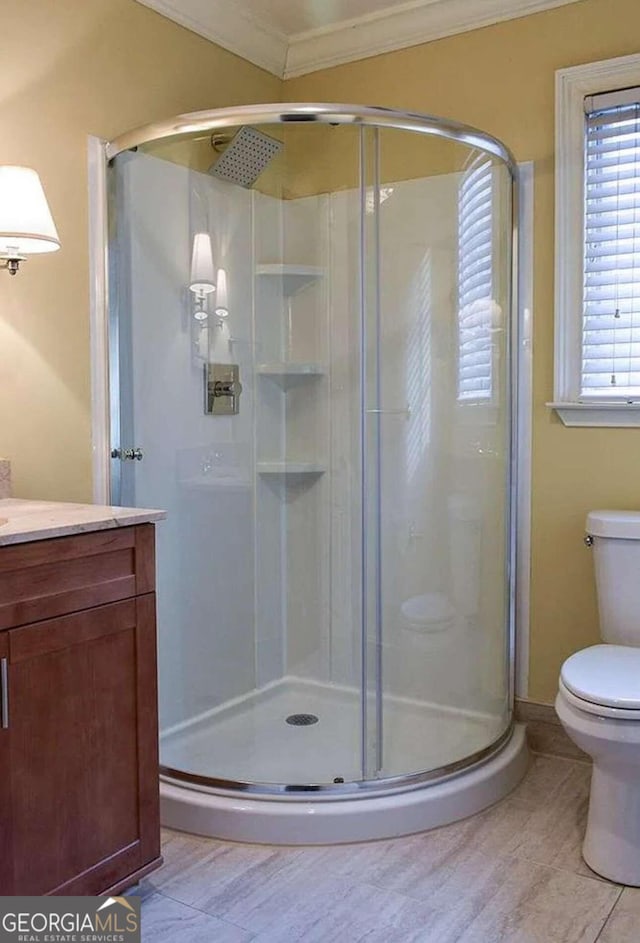 bathroom with vanity, ornamental molding, toilet, and walk in shower