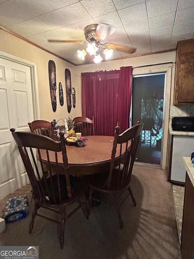 carpeted dining space featuring ceiling fan