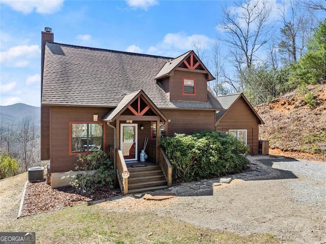 view of front of property with a porch, cooling unit, and a mountain view