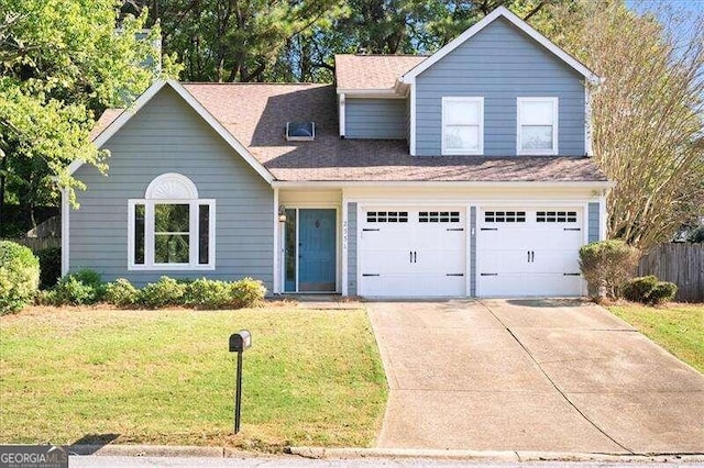 view of property with a garage and a front lawn