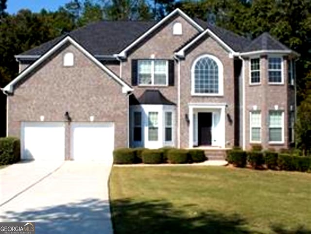 view of front of property featuring a garage and a front lawn