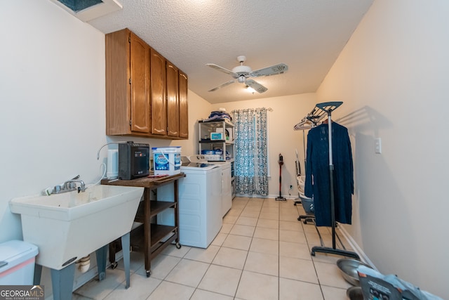 washroom featuring cabinets, ceiling fan, washing machine and dryer, light tile patterned floors, and a textured ceiling