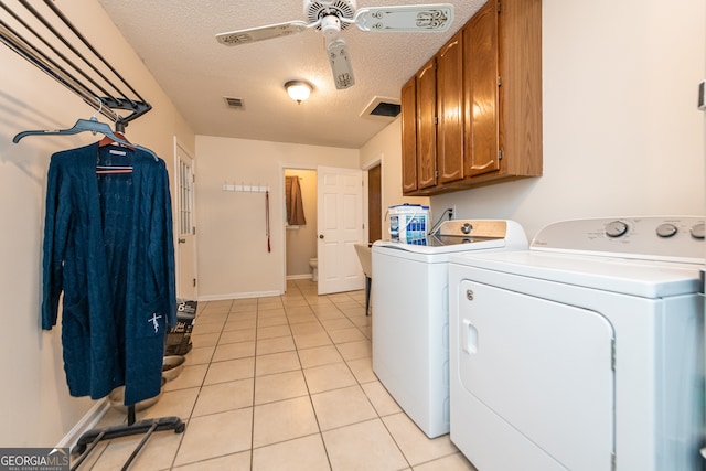 washroom with cabinets, a textured ceiling, ceiling fan, washer and dryer, and light tile patterned flooring