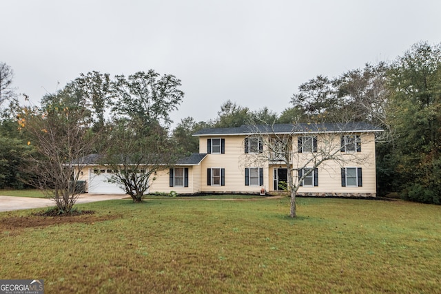 colonial inspired home with a front yard and a garage