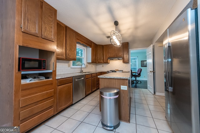 kitchen featuring sink, a center island, hanging light fixtures, light tile patterned floors, and appliances with stainless steel finishes