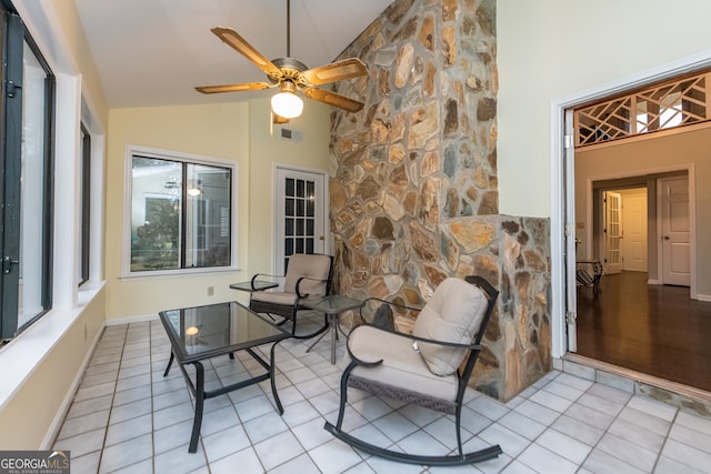 interior space featuring light tile patterned floors, high vaulted ceiling, and ceiling fan