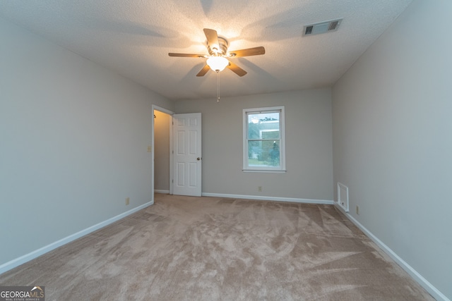 carpeted empty room featuring ceiling fan and a textured ceiling