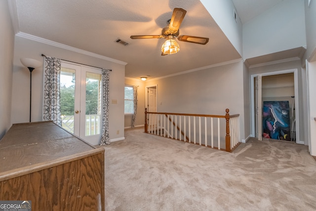 interior space featuring ceiling fan, french doors, carpet floors, and ornamental molding