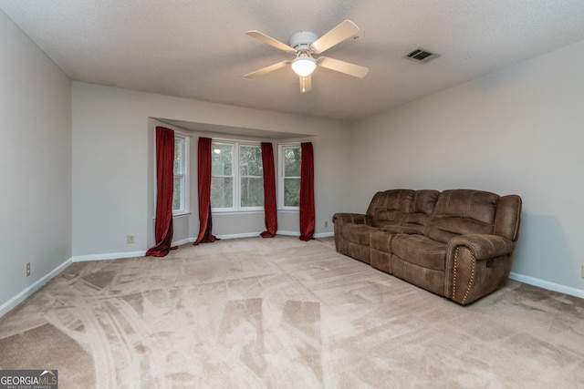 sitting room featuring light carpet, ceiling fan, and a textured ceiling