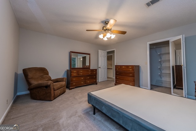 bedroom with light carpet, a textured ceiling, a closet, and ceiling fan