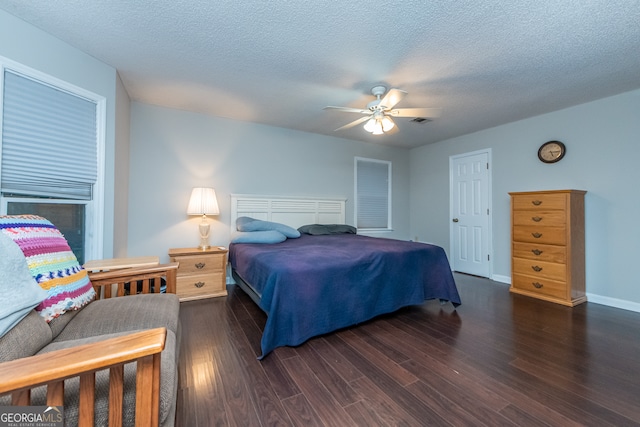 bedroom featuring ceiling fan, dark hardwood / wood-style flooring, and a textured ceiling