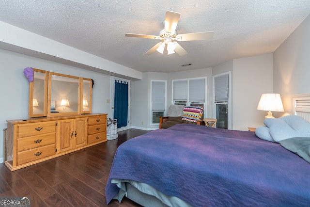 bedroom featuring ceiling fan, dark hardwood / wood-style flooring, and a textured ceiling