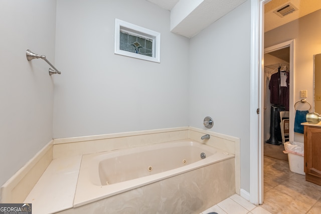 bathroom with tile patterned flooring and a bath