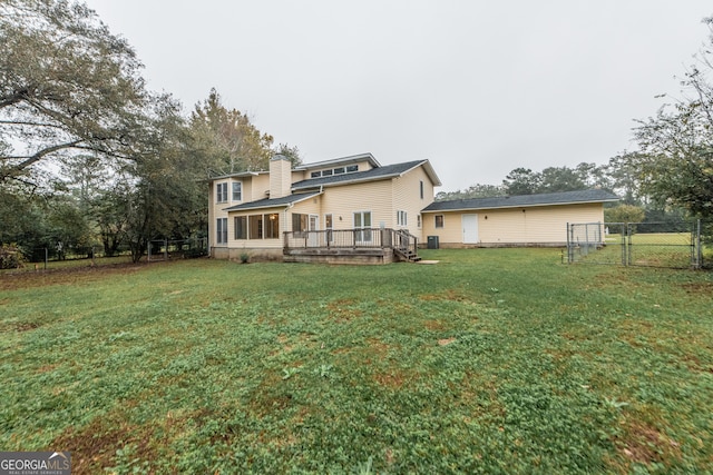 rear view of house with a yard and a deck