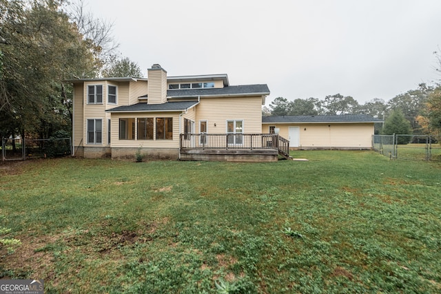 back of property featuring a yard and a wooden deck