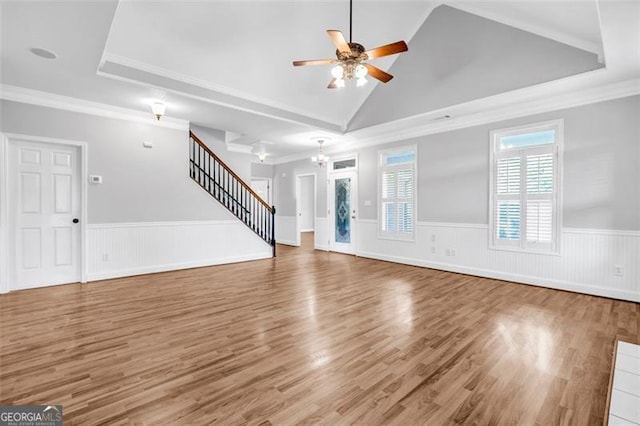 unfurnished living room featuring hardwood / wood-style flooring, lofted ceiling, ornamental molding, and ceiling fan with notable chandelier