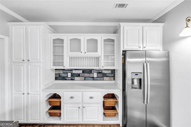 kitchen with stainless steel refrigerator with ice dispenser, white cabinets, and ornamental molding