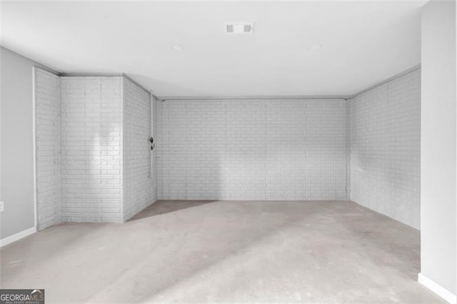 unfurnished room with brick wall